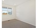 Bright empty bedroom with neutral carpet, window with blinds, and natural light at 8898 Salida St, Commerce City, CO 80022