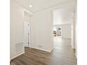 Hallway with wood floors leading to bright living space with sliding glass doors at 8898 Salida St, Commerce City, CO 80022