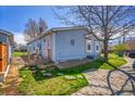 Exterior view of home with a side porch and a driveway and mature landscaping at 6631 E 78Th Avenue Ave, Commerce City, CO 80022
