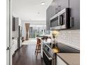 Modern kitchen features stainless steel appliances, white subway tile backsplash and hardwood floors at 2550 Lawrence St # Rb306, Denver, CO 80205