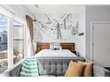 Main bedroom with ski lift wall art, hardwood floors and couch overlooking private balcony at 2550 Lawrence St # Rb306, Denver, CO 80205
