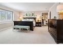 This bedroom suite features plantation shutters, neutral paint and carpet and ensuite bath at 6375 E Tufts Ave, Englewood, CO 80111