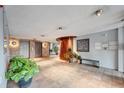 The condominium building's lobby features tile floors, lush greenery, and elevator access at 909 N Logan St # 3C, Denver, CO 80203