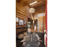 Inviting entryway with unique lighting, tile floors, log walls, and views into the great room at 29095 Summit Ranch Dr, Golden, CO 80401