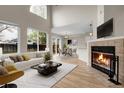 Bright living room with large windows, a fireplace, and an adjacent dining area at 16928 Dandelion Way, Parker, CO 80134