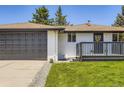A single-story home shows an attached garage, small deck, and manicured lawn at 4475 S Routt St, Littleton, CO 80127