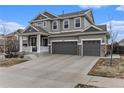 Inviting two-story home features stone accents, a covered porch, and a three-car garage, all under a bright blue sky at 6480 S Newcastle Way, Aurora, CO 80016