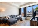 Living room with couch and city view at 1750 Wewatta St # 728, Denver, CO 80202
