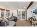 Inviting living room featuring a comfortable gray sectional sofa, carpet, and a sliding door to the deck at 100 Now Colorado Ct # D1, Breckenridge, CO 80424