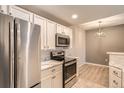 Well-lit kitchen with modern stainless steel appliances, white cabinets, and dining area at 7440 S Blackhawk St # 4-104, Englewood, CO 80112
