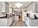 Efficient kitchen with white appliances, sleek countertops, and an open layout leading to the dining area at 13742 W 67Th Pl, Arvada, CO 80004