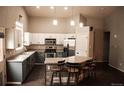 Bright kitchen features white cabinets, stainless appliances, and a large island with seating for a modern look at 11384 Oakland Dr, Commerce City, CO 80640