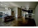 Spacious living room with hardwood floors features a fireplace and seamlessly connects to the modern kitchen at 11384 Oakland Dr, Commerce City, CO 80640