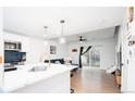 Open-concept kitchen flows into the living area, featuring a breakfast bar, stainless appliances, and modern lighting at 1543 S Ouray Cir # B, Aurora, CO 80017