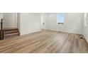 Spacious living room showcasing hardwood floors, staircase to the upper level and entry to the home at 2116 Chambers Rd, Brighton, CO 80601