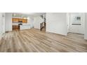 Open-concept living area featuring hardwood floors, bright natural light, and staircase to the upper level at 2116 Chambers Rd, Brighton, CO 80601