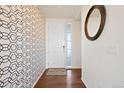Bright entryway with patterned wallpaper and hardwood floors, creating a welcoming entrance to the home at 10554 Casper Pt, Parker, CO 80134