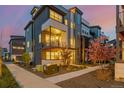 Modern home exterior featuring a balcony and lush landscaping with flowering trees at 6776 Navajo Way, Denver, CO 80221