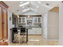 Bright kitchen with skylights, pendant lights, white cabinetry, and breakfast bar at 901 S Leyden St, Denver, CO 80224