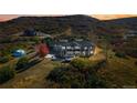 Luxurious home featuring a swimming pool, sprawling landscape, and breathtaking mountain views at sunset at 1967 Haystack Rd, Castle Rock, CO 80104