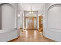 Elegant foyer features arched doorways, hardwood floors, and a beautiful wood front door with leaded glass at 1967 Haystack Rd, Castle Rock, CO 80104