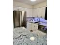 Bright kitchen featuring stainless steel fridge and modern appliances, with beautiful granite countertops at 10251 W 44Th Ave # 3-204, Wheat Ridge, CO 80033