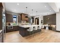Eat-in kitchen showcasing an oversized island with stools, custom cabinets, and modern lighting at 1100 S Elizabeth St, Denver, CO 80210