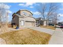 A beautiful two-story home featuring an attached two-car garage and manicured lawn at 5211 E 116Th Ave, Thornton, CO 80233