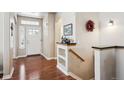Welcoming foyer features gleaming hardwood floors, a decorative shelf, and abundant natural light at 1844 S Jay Way, Lakewood, CO 80232
