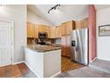 Well-lit kitchen with stainless steel appliances, granite countertops, and wood-look flooring at 8778 S Kipling Way # 304, Littleton, CO 80127