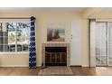 Living room with cozy fireplace, light-filled window, and access to a sliding glass door at 4084 S Carson St # A, Aurora, CO 80014