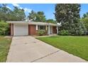 Exterior view of brick home with driveway and one car garage at 8304 Eaton Way, Arvada, CO 80003