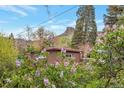 Brick house surrounded by flowering bushes, lush trees, and scenic mountain views at 2015 Arapahoe St, Golden, CO 80401