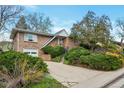 Charming brick home with an attached garage, mature landscaping, and a well-maintained front yard at 2015 Arapahoe St, Golden, CO 80401