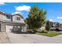 Two-story townhome with attached garage and a tree in front at 6005 Turnstone Pl, Castle Rock, CO 80104