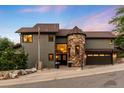 Inviting two-story home featuring stone accents, mature trees, and a well-manicured front yard at 600 Cascade Dr, Golden, CO 80403