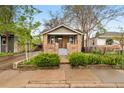Charming home with a brick facade, inviting front porch, and well-manicured landscaping at 2731 S Logan St, Englewood, CO 80113