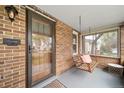 Inviting covered front porch with brick accents, swing, and a view of the neighborhood at 2731 S Logan St, Englewood, CO 80113