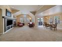 Open living room with fireplace, vaulted ceilings, carpet floors and dining area at 7750 S Buchanan Way, Aurora, CO 80016