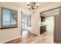 Open-concept dining area featuring modern light fixture and hardwood floors that transitions to the kitchen at 10890 W Evans Ave # 3D, Lakewood, CO 80227