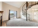 Open living room with vaulted ceiling, a fireplace, a spiral staircase, and sliding glass doors to the balcony at 10890 W Evans Ave # 3D, Lakewood, CO 80227