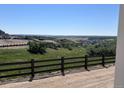 Sweeping view of the rolling hills and landscape that overlook the home and fence at 4316 Ridgewalk Pt, Arvada, CO 80007