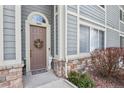 Charming condo entrance with a wreath, decorative stone accents, and a welcoming doorway at 1404 Whitehall Dr # C, Longmont, CO 80504
