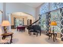 Elegant living room showcasing a grand piano, chandelier, and large windows with patterned curtains at 3343 W 109Th Cir, Westminster, CO 80031