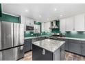 Modern kitchen features stainless steel appliances, gray cabinets, granite countertops, and a center island at 2650 S Vaughn Way # D, Aurora, CO 80014