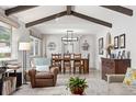 Open-concept living and dining areas with exposed ceiling beams, modern light fixtures, and large windows at 452 Deframe Ct, Golden, CO 80401