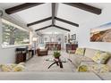 Open living room features vaulted ceilings with exposed beams, carpet flooring, and a large picture window at 452 Deframe Ct, Golden, CO 80401