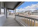 Covered front porch with white railings overlooking the neighborhood at 12243 Joplin St, Commerce City, CO 80603