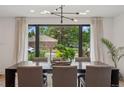 Bright dining room featuring a modern chandelier, large windows, and stylish furnishings at 4634 W Tufts Cir, Denver, CO 80236