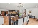 Open dining room showcases a large table, modern chandelier, and seamless flow to the kitchen at 4634 W Tufts Cir, Denver, CO 80236